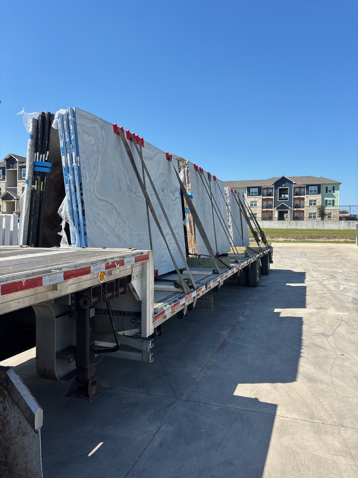 Ace step deck trailer hauling stone slabs